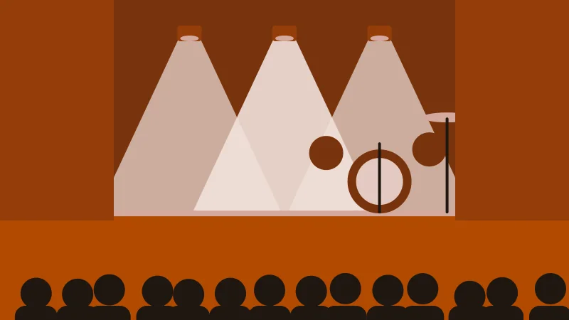 A lit stage between dark curtains, three lamps above a drum kit, an audience in silhouette